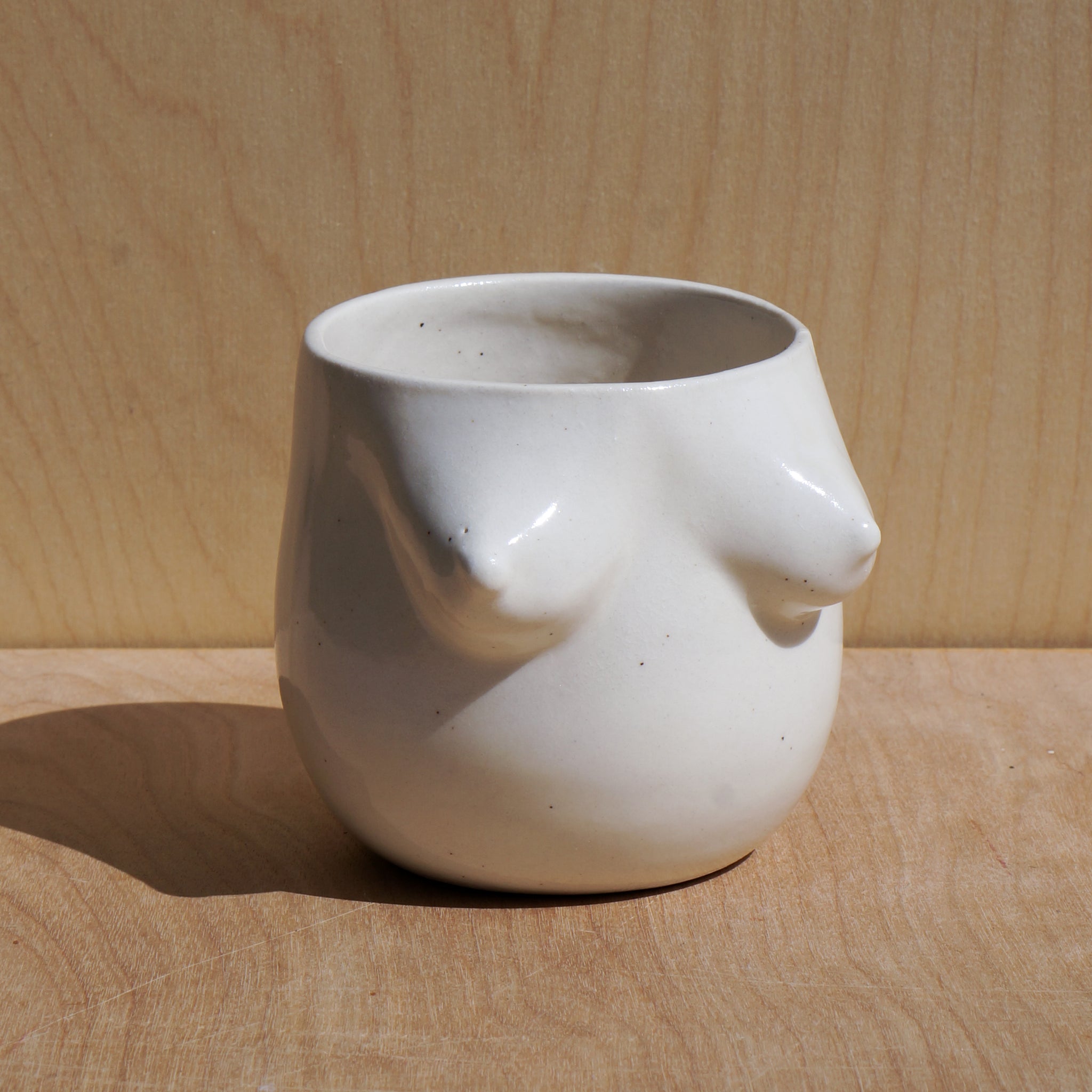 A white ceramic tumbler featuring the female form. 
