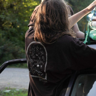 Beach Wavey hair model wearing Goofy Apparel Dark Brown T with back graphic